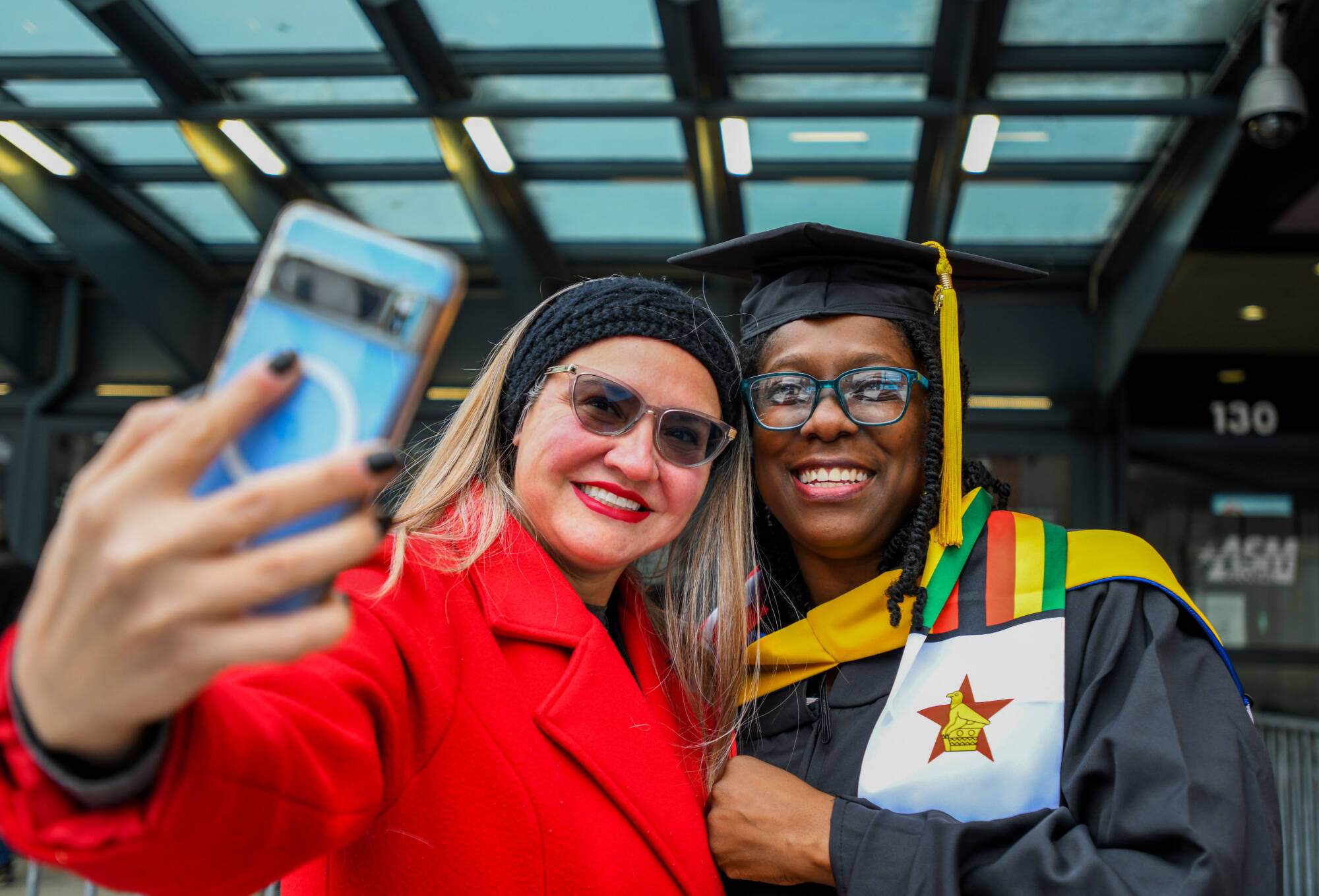 Holli Reyes, College of Computing International Student Engagement Coordinator, left, takes a selfie with Merrilyn Chizanga who was getting a masters degree in health informatics and bioinformatics.